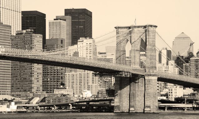 New York City Brooklyn Bridge in Manhattan closeup with skyscrapers and city skyline over Hudson River.